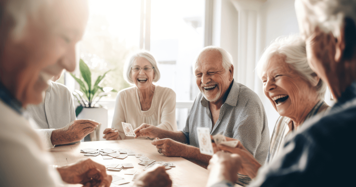 Group of senior living members gathered around the table laughing.