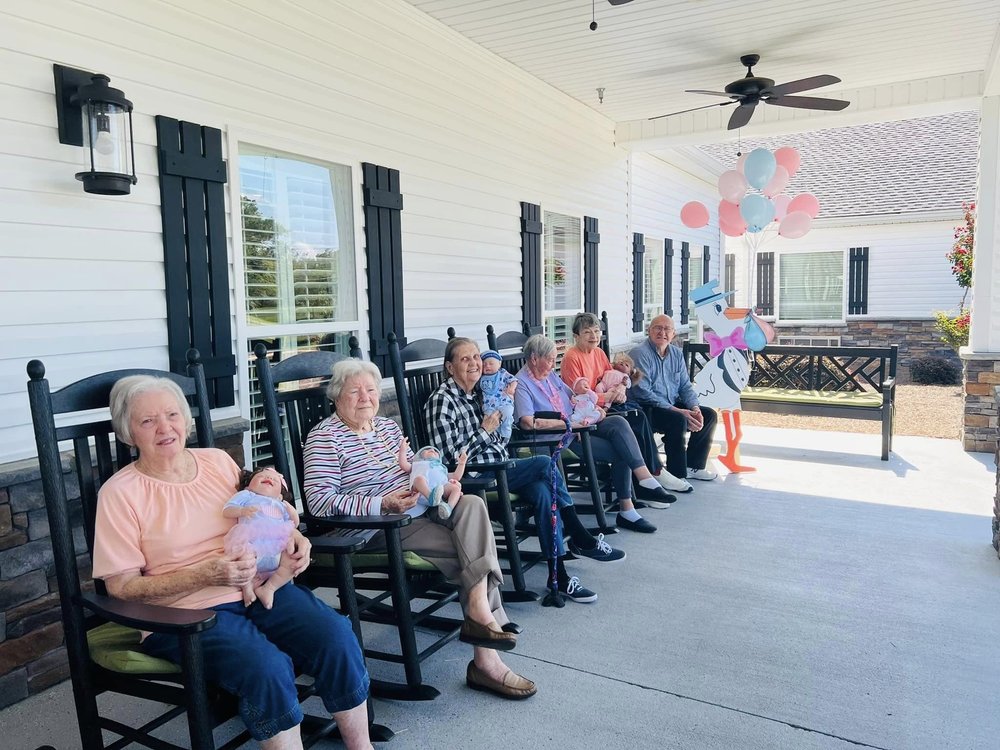 Seniors with dolls and a stork cutout