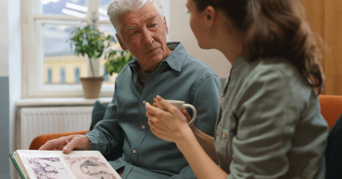 Senior man speaking to caregiver about services in memory care services.