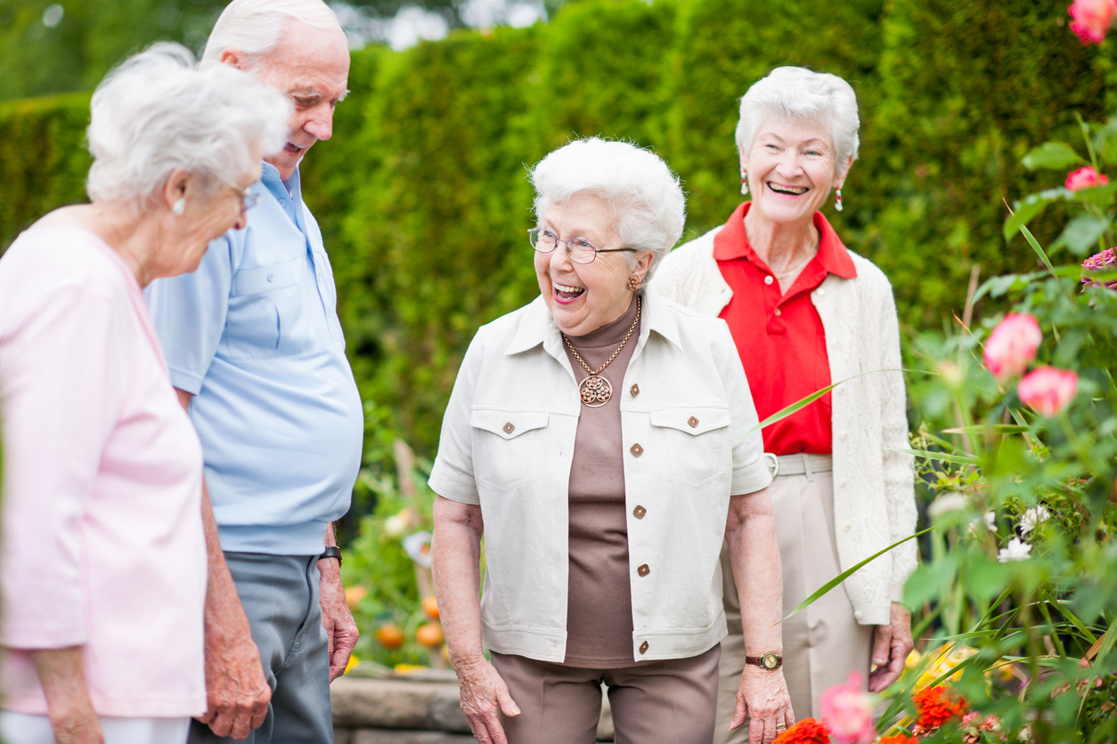 Seniors outside walking by the garden